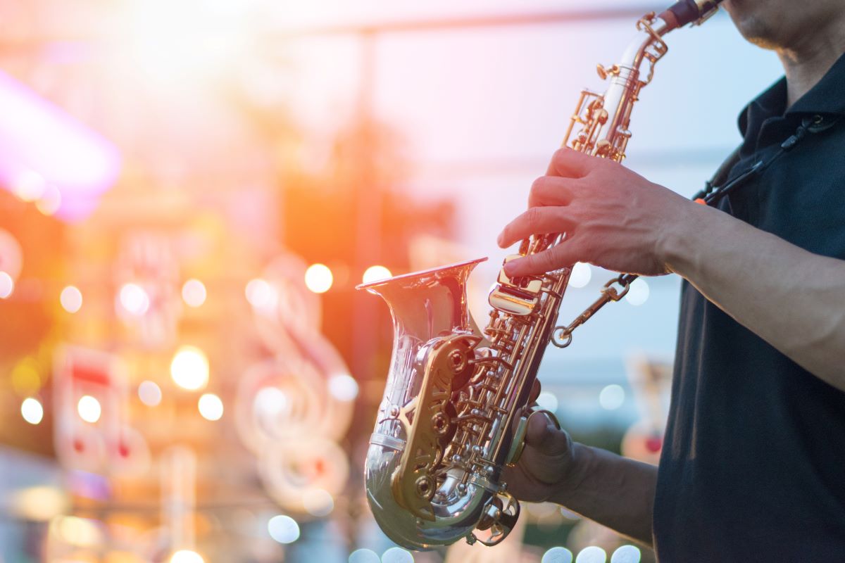 A man plays saxophone at a festival.